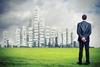 Businessman looking at city skyline which includes leadersip phrases such as "success"